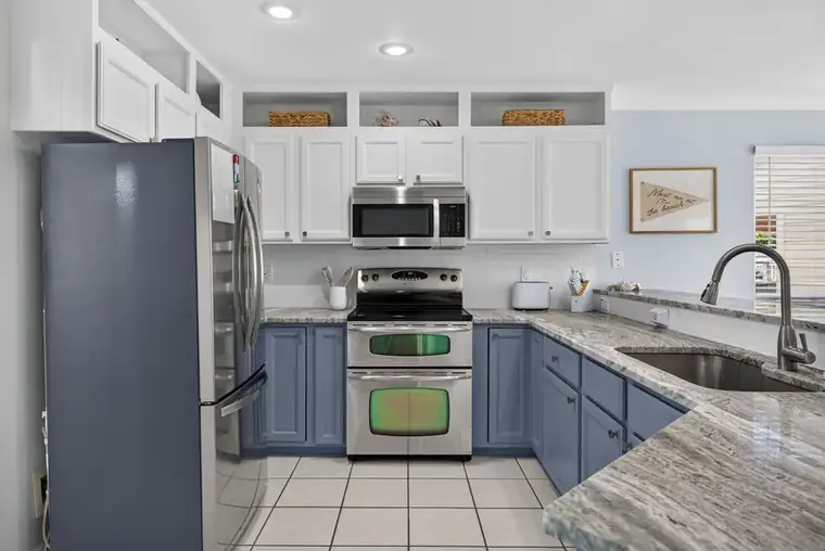 Kitchen with stone counters and blue cabinetry