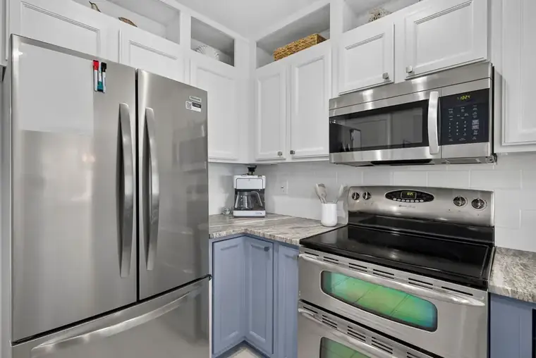 Kitchen with full-size stainless refrigerator and microwave