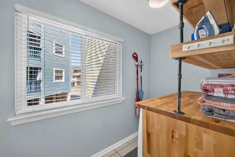 Laundry room with butcher block folding counter and open shelving