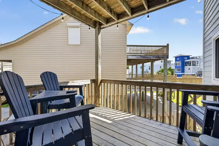Covered deck with Adirondack chairs and string lights